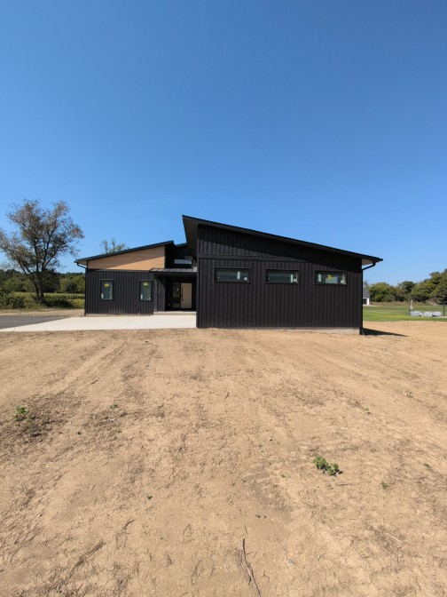 Finished exterior of The Apex Modern with black vertical siding and a shed roof