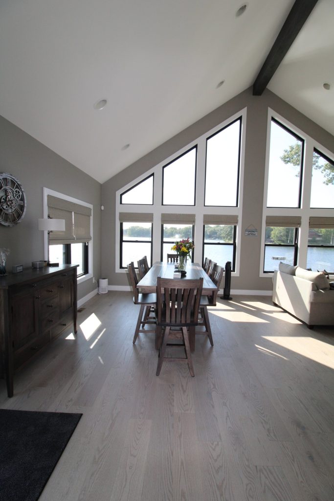 Great room with a wall of lake-view windows and a vaulted ceiling at The Lake House