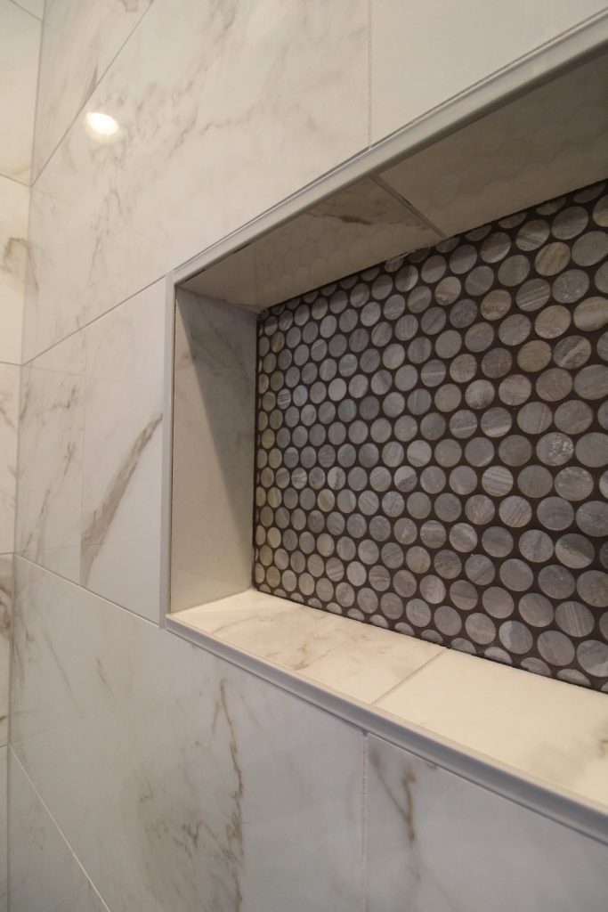 Tiled shower niche with a penny-tile accent at The Lake House