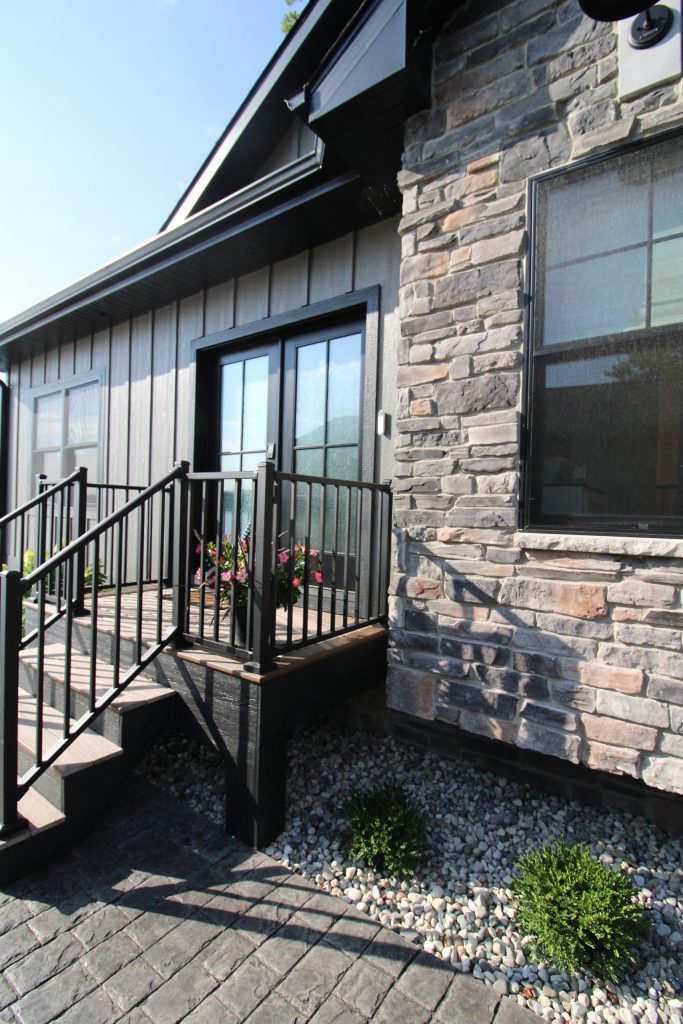 Stone and siding exterior detail beside the entry steps at The Lake House