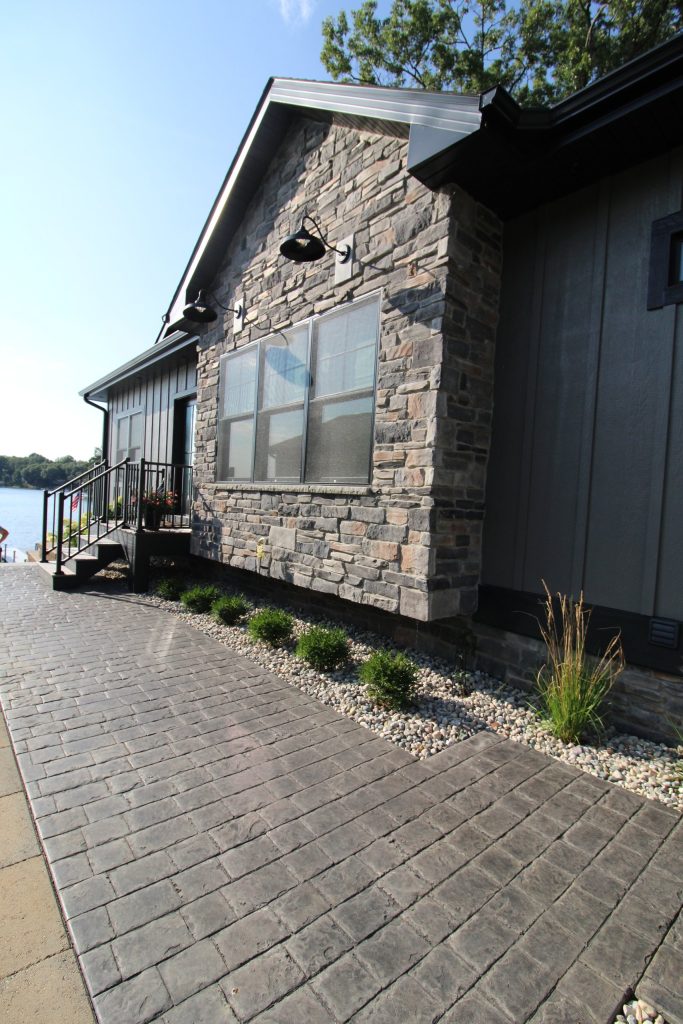 Paver walkway along the stone exterior toward the lake at The Lake House