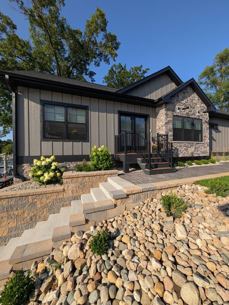 Exterior of The Lake House with stone accents, landscaping and a retaining wall